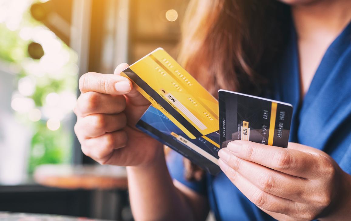 Close-up beeld van een vrouw die creditcard houdt en kiest om het te gebruiken