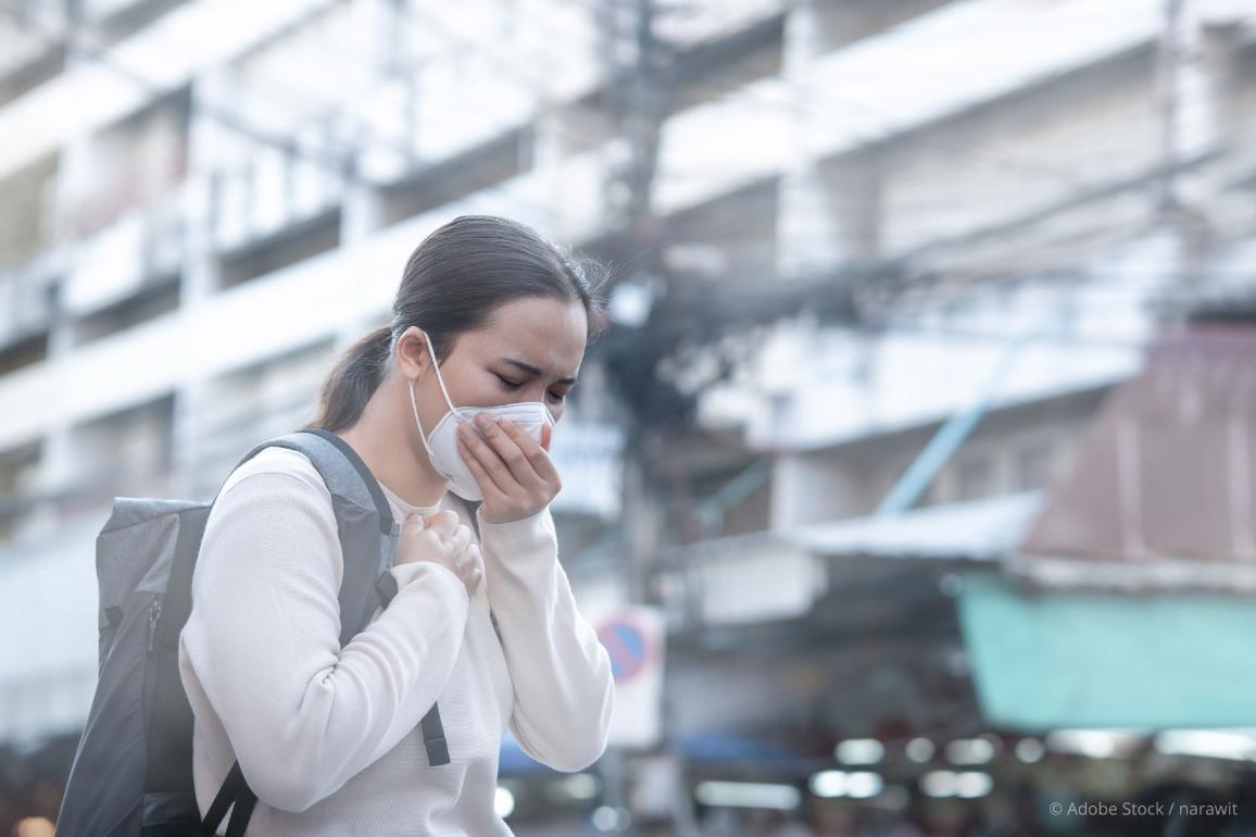 young woman wears a mask to protect against air pollution