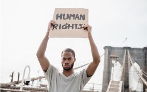 man holding a sign saying human rights