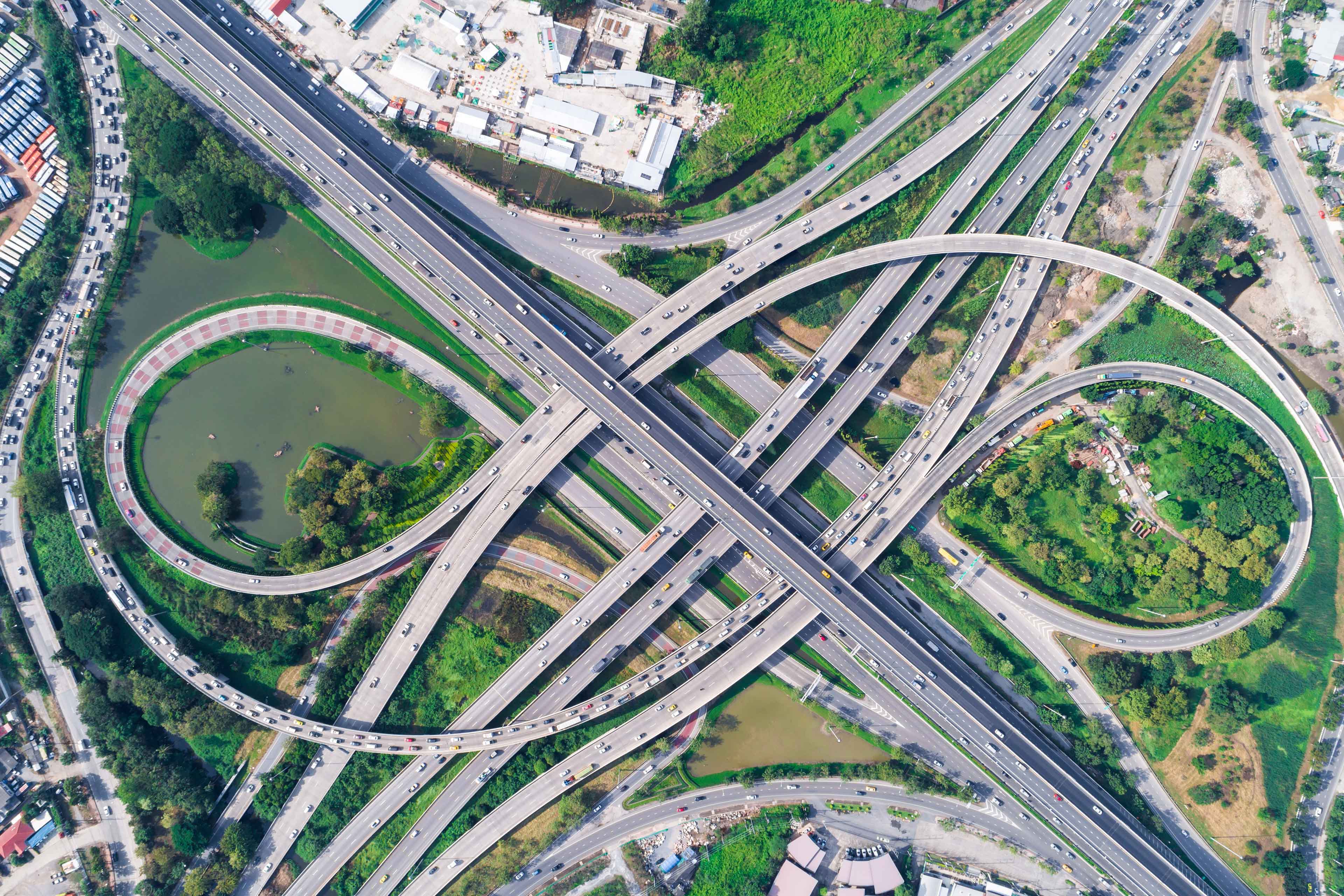 Traffic road junction view from above with green tree