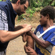 Dr. Hagan works with a mother holding her infant