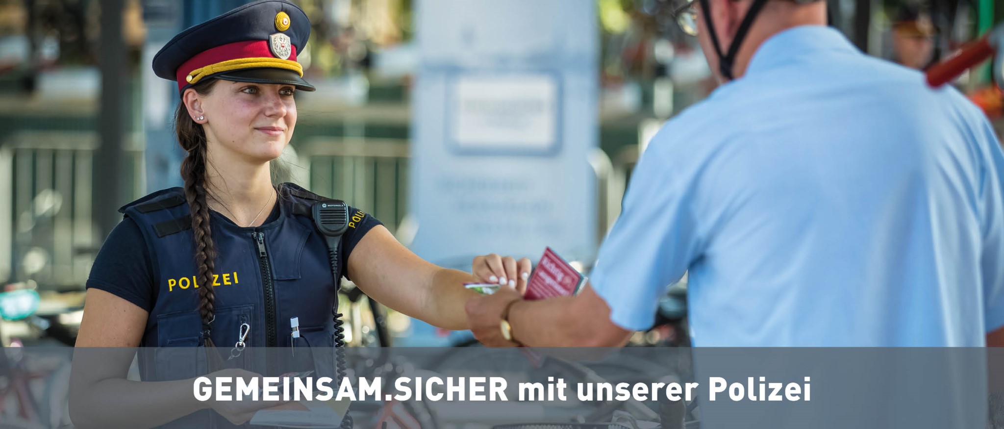 Polizist mit Sicherheitsbeauftragten und BürgerInnen