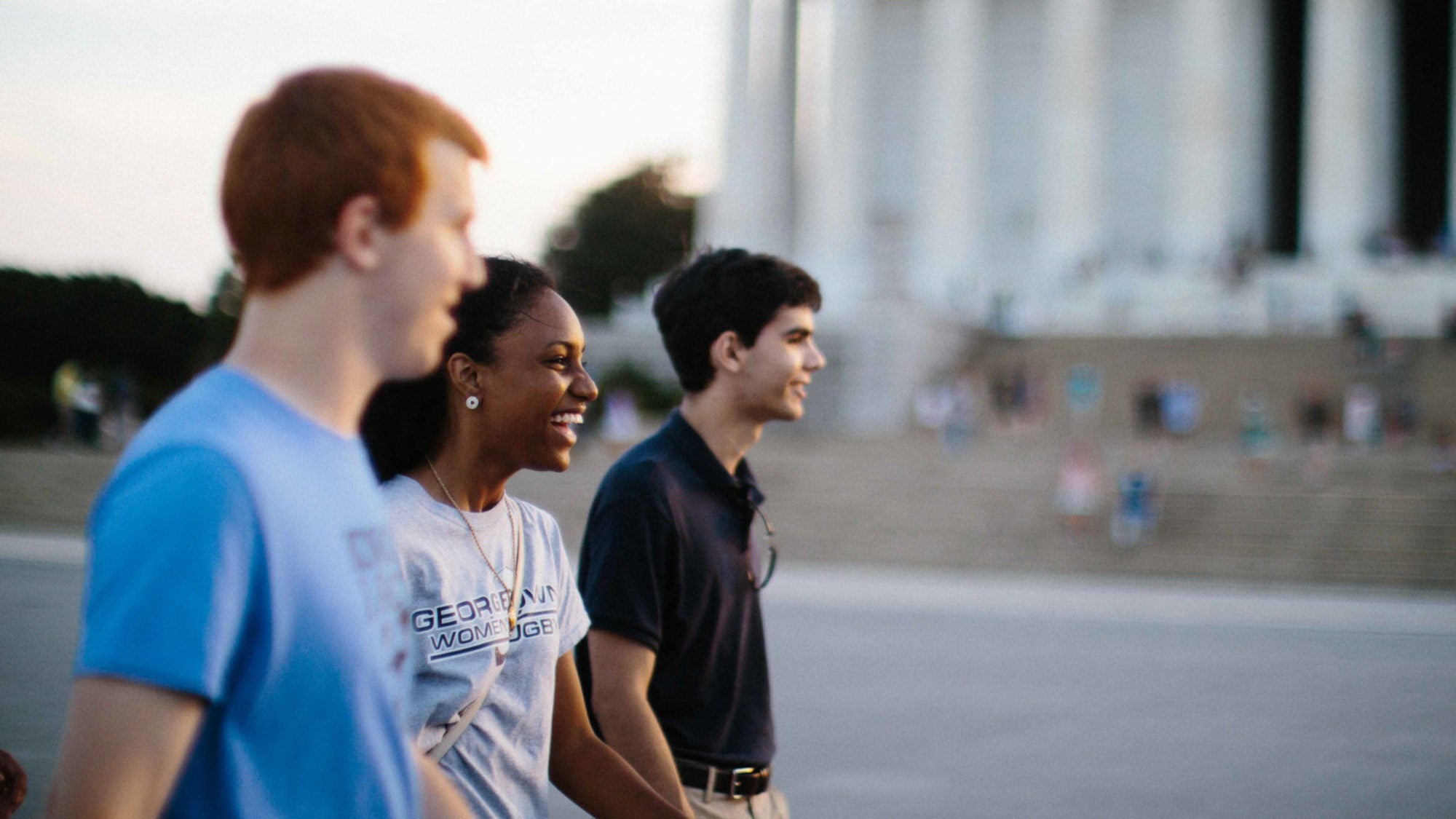 Three students walk by the monuments.