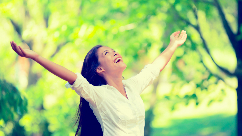 A cheerful woman in a park; image used for HSBC Singapore Credit Card Balance Transfer