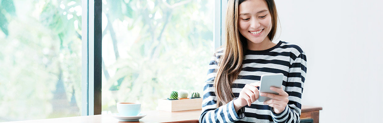 A woman is using her mobile phone; image used for HSBC Singapore Promotions.