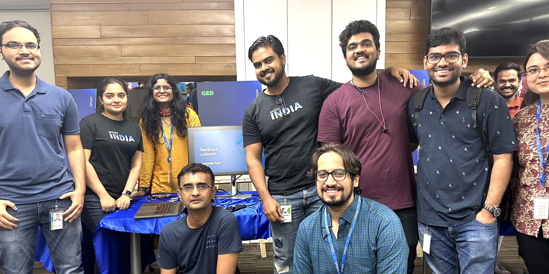 A group of people standing next to each other in front of a desk.