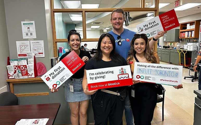 A group of people standing in front of a sign.