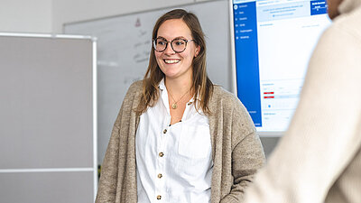 Young employee gives a presentation and looks happily to the right