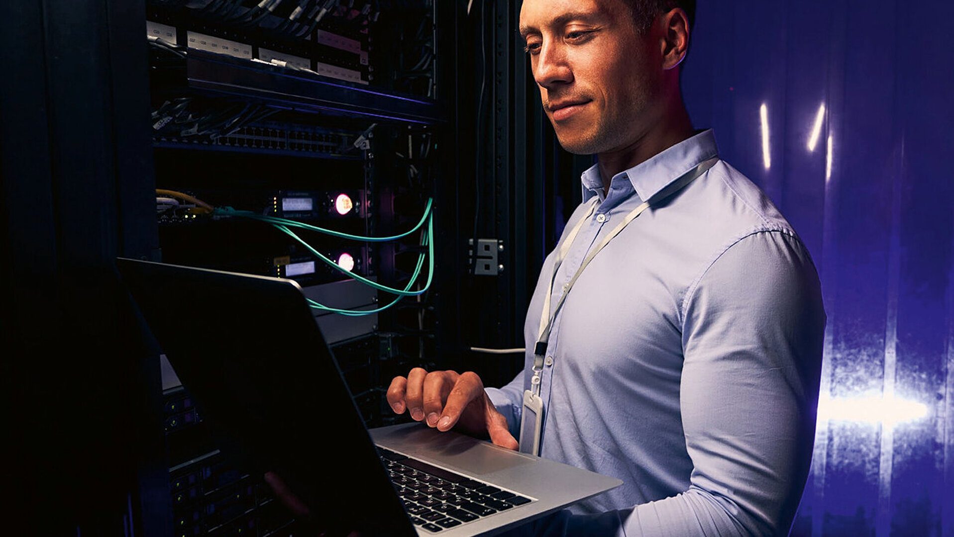 Cover image of the reading sample for the techconsult and LANCOM Campus Networking study: At the top is a young IT employee in a light blue shirt with a security badge, standing in a server room with his laptop open on his arm; above this the document is labeled “Reading Sample”; in the lower third of the image are the title and subtitle of the document (“Campus Networking: Powerful Networks in Medium-Sized Company IT”) as well as the logos of LANCOM Systems and techconsult.  