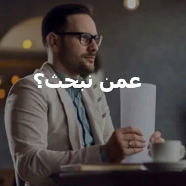 رجل يجلس على مكتب ممسكًا بحزمة من الأوراق