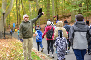 man holding raven as runners pass