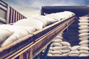 grain bags on conveyor belt headed into a semi truck for transport