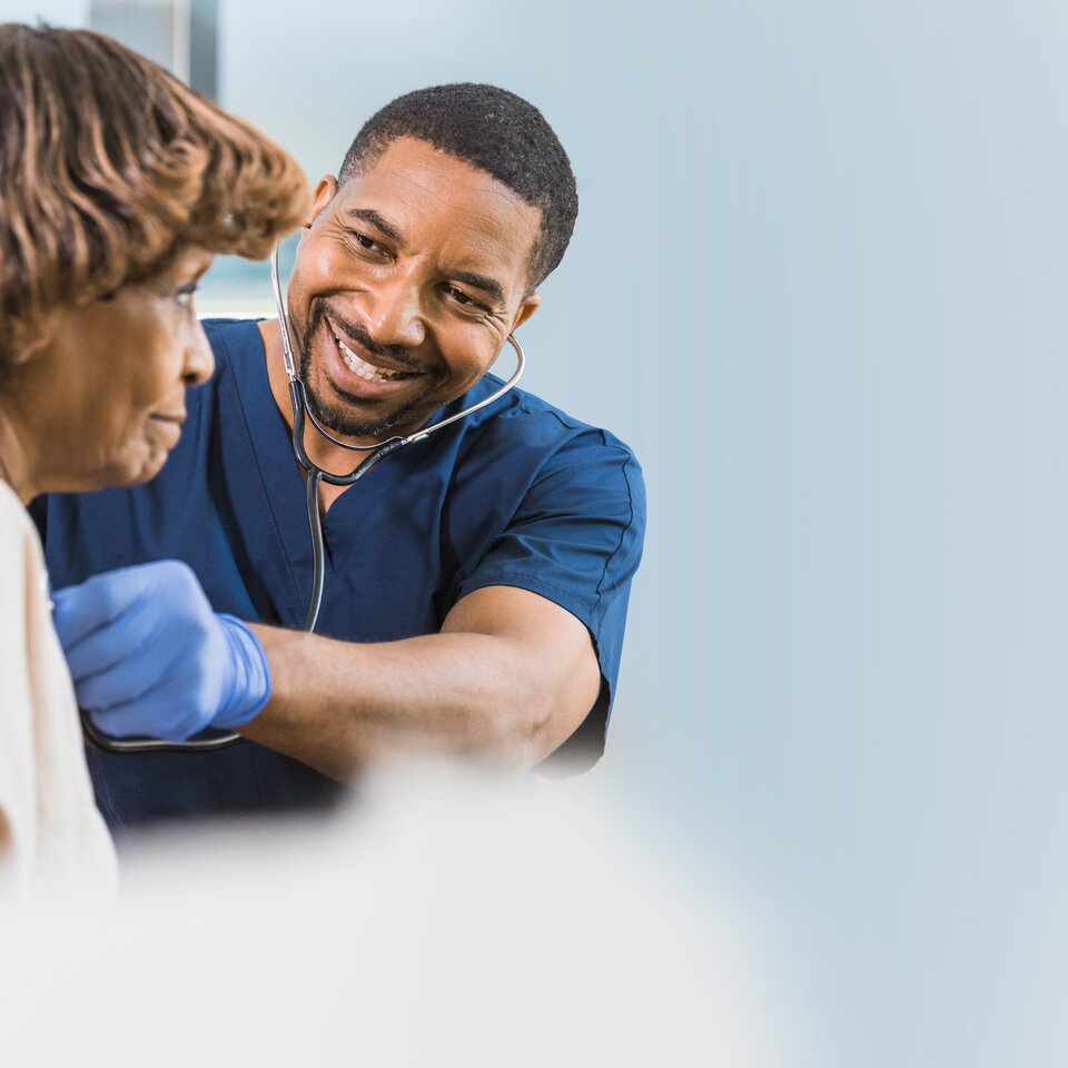 Médecin écoutant le cœur d'une femme à l'aide d'un stéthoscope