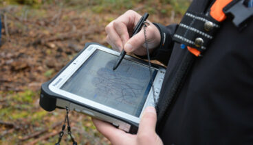 A Metsähallitus employee is using the geographic information system on a terminal.