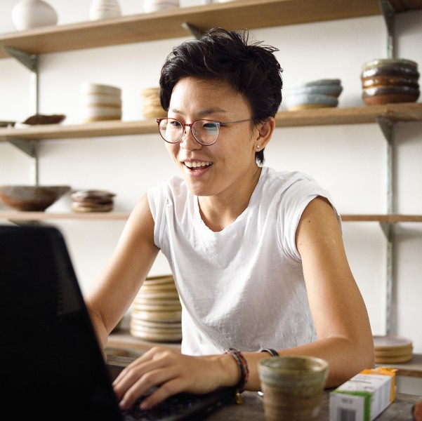 Young business owner working on a laptop in her studio workplace.