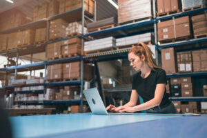 woman using computer in storeroom