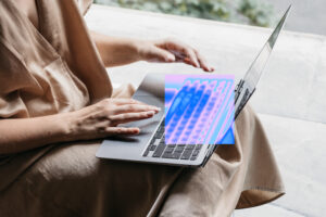 Close-up of a person typing on a laptop