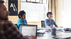 a group of people looking at a laptop