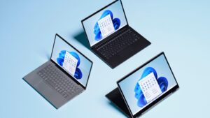 Three devices are arranged in a triangle with each showing a Windows 11 homepage.