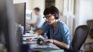 A Microsoft employee works at her desk in an open work area in a Microsoft building.