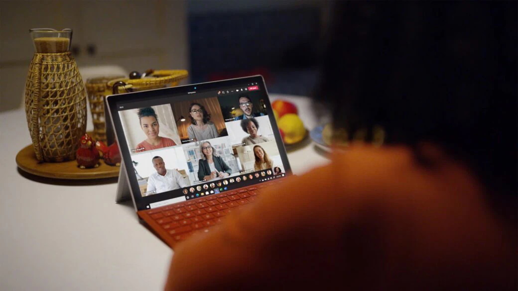 Laptop on a table, displaying a Microsoft Teams meeting in progress, with multiple participants.