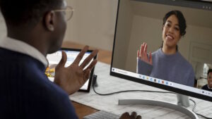 Male and female coworkers on Microsoft Teams call using webcam.