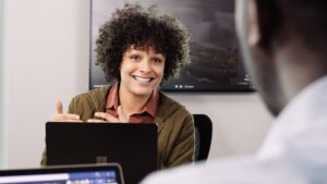 A Microsoft employee gestures to another while talking during a meeting.