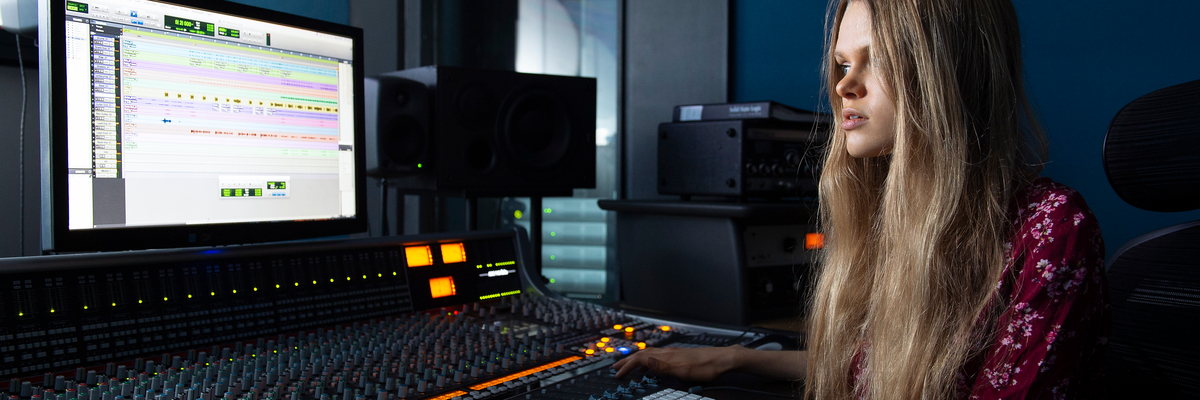 Female student operating a mixing desk