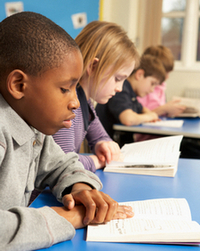 Group of school children working in classroom 