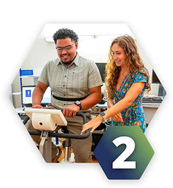 A man on an exercise bike next to a woman in a lab setting