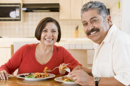 Foto de una pareja de ancianos haciendo una comida saludable para el corazón.