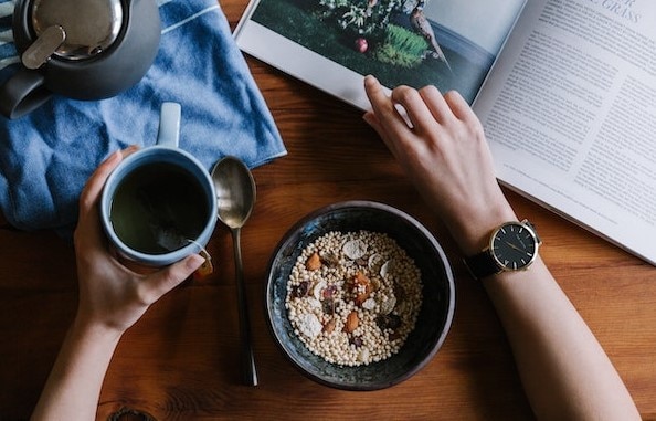 Overhead view of person eating a meal while reading a book