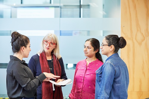 Four women meeting and talking in an office