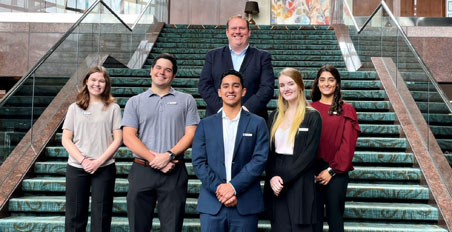 Omni students and graduates on a staircase