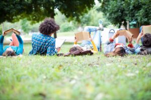 Studierende liegen auf Wiese