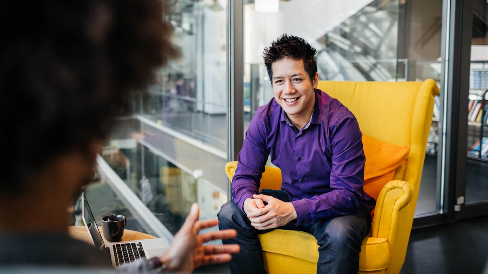 man smiling chatting to colleague