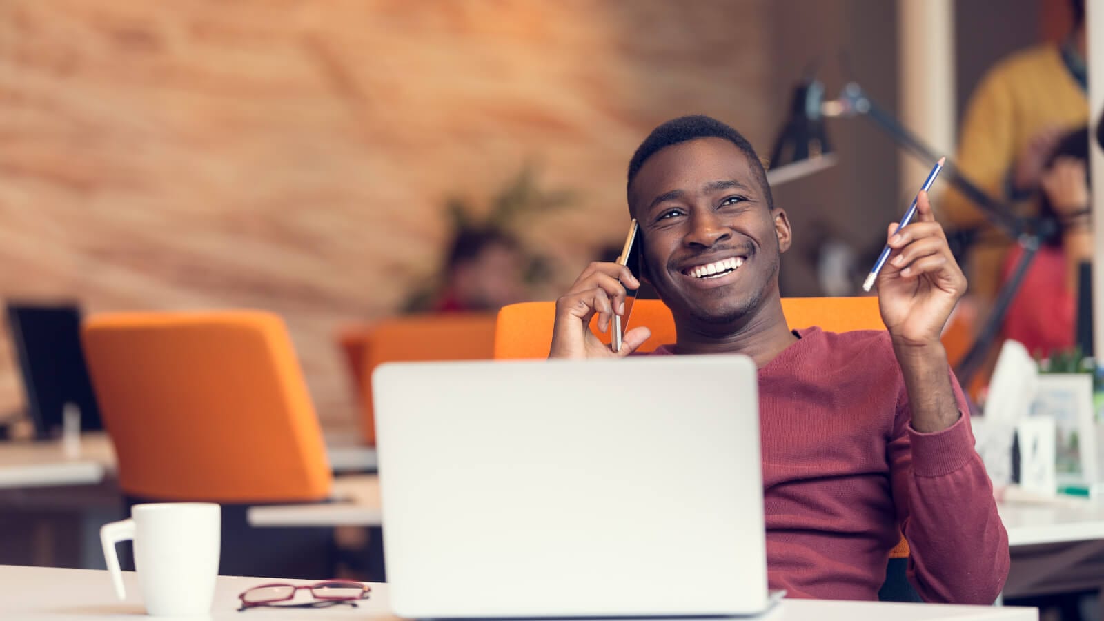 Man working at laptop on a phone call