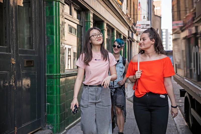 Three students walking along a street