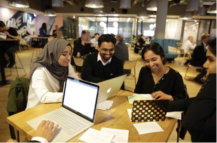 People sitting around a table with computers and notes