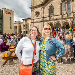 Image shows two staff members enjoying the Pride Picnic Celebration.