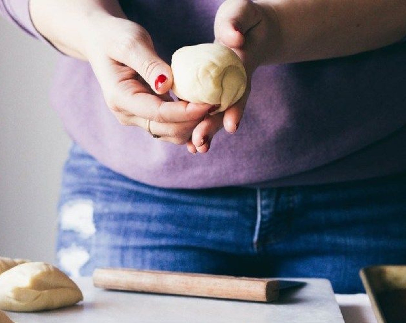 step 7 Take each dough and wrap the sides around to the bottom center of the dough and continue to do that until a clean ball forms. Place on a lined cookie sheet and cover with a clean towel while you make the topping.