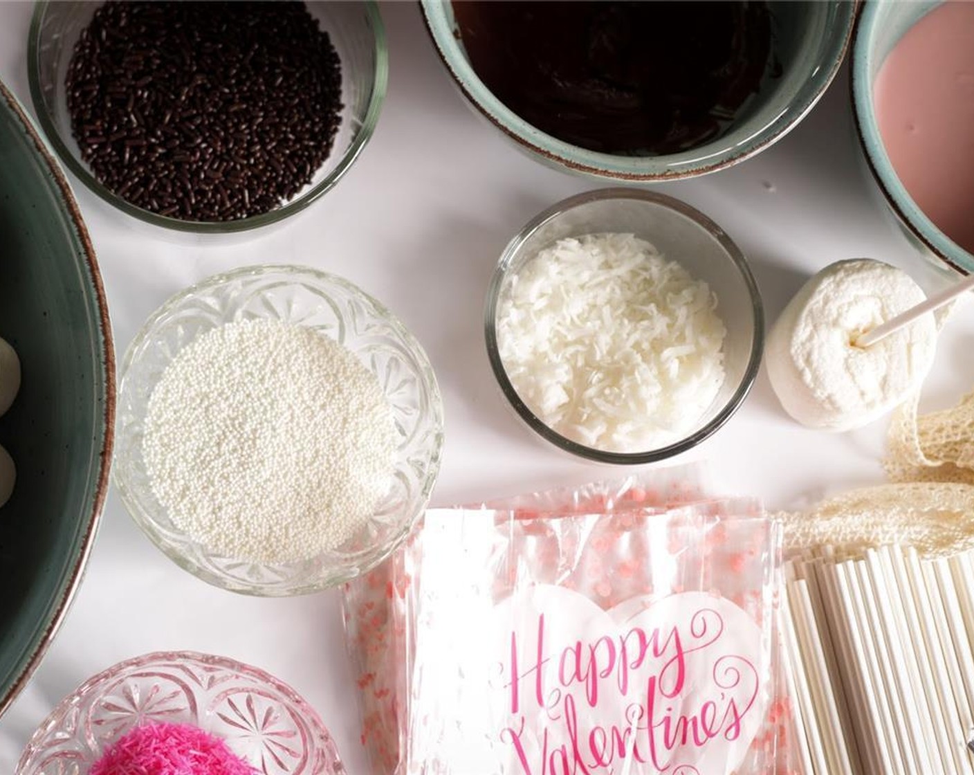 step 1 Prepare a work surface by placing lollipop sticks, Large Marshmallows (1 pckg), Unsweetened Shredded Coconut (to taste), Sprinkles (to taste), and Assorted Nuts (to taste) in separate bowls. Arrange 3 cups to place dipped marshmallows for drying, and bags and ribbons for wrapping once dry.