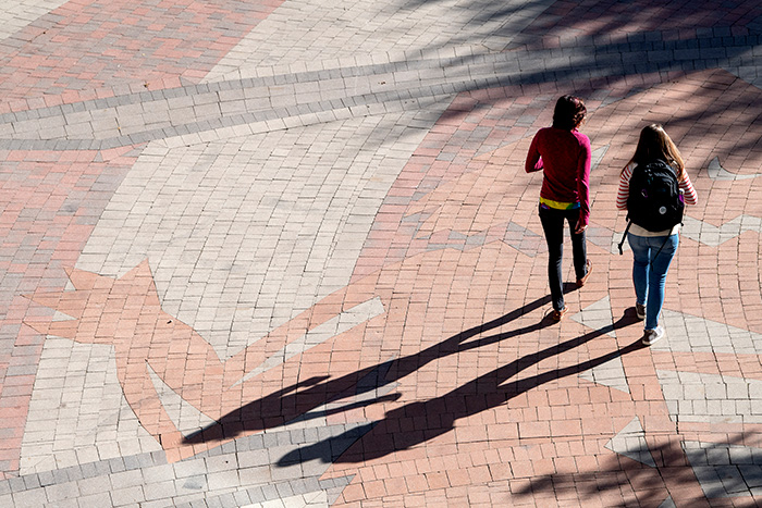 Two students walking through the Campus Commons