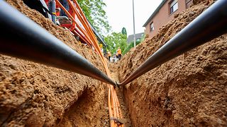 Ein schmaler und tiefer Graben im Gehweg, in dem Leerrohre verlegt werden.