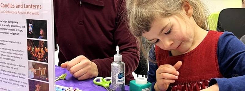 Adult and child work on a craft project together.