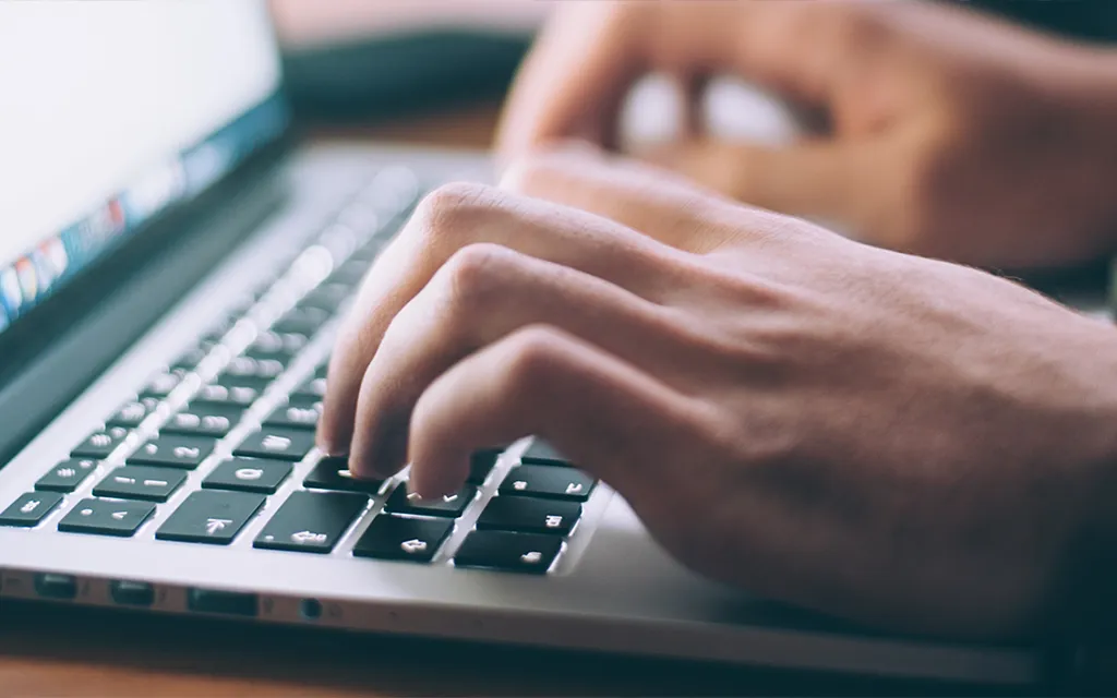 A student typing on a laptop