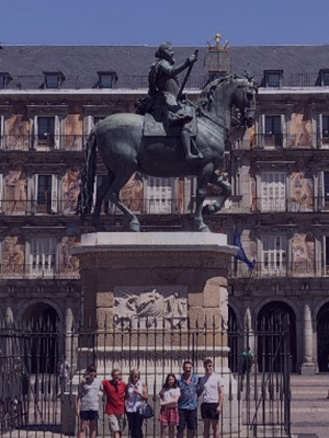 group shot of students in front of a statue of a man on horseback