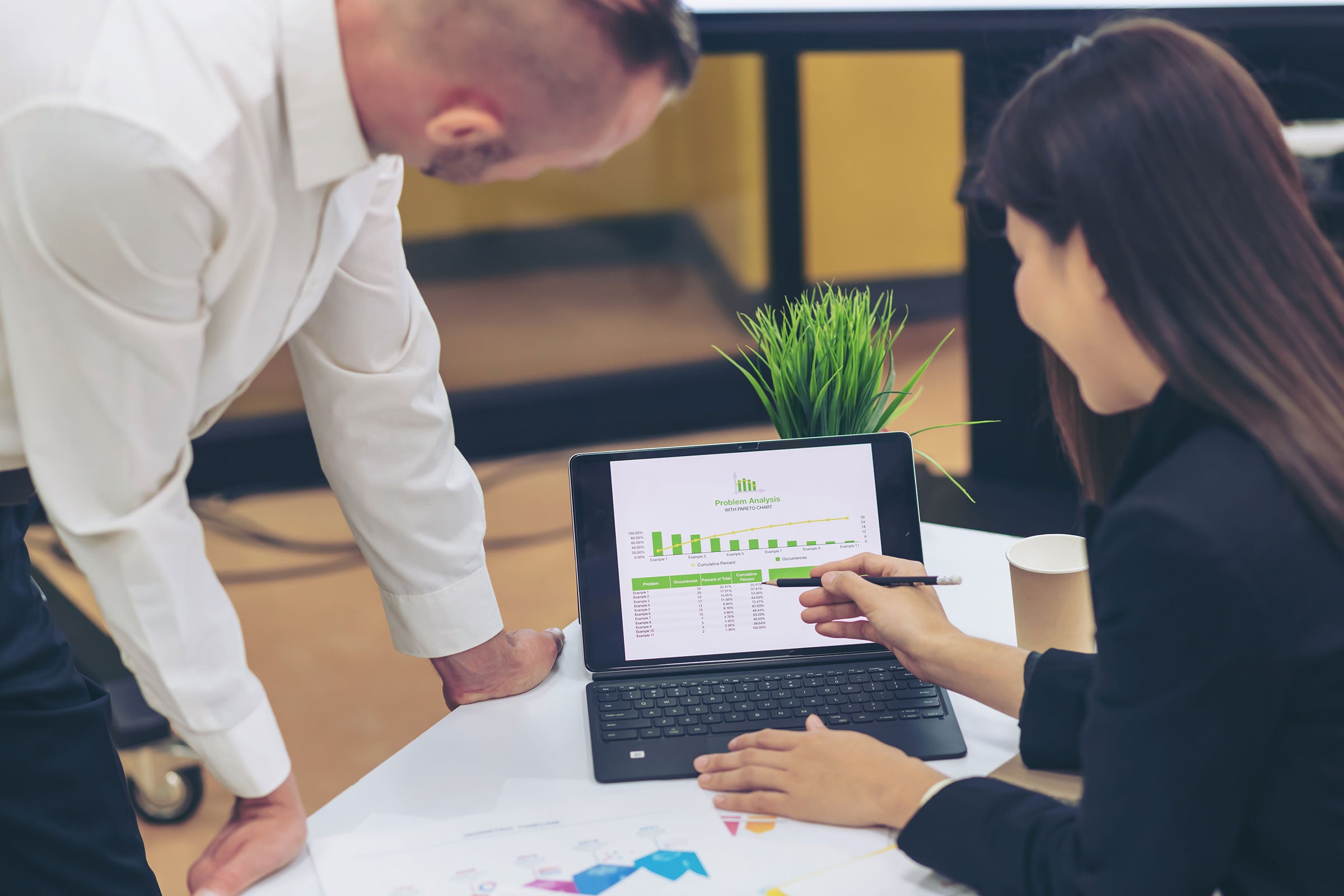 Two colleagues looking at metrics on a laptop