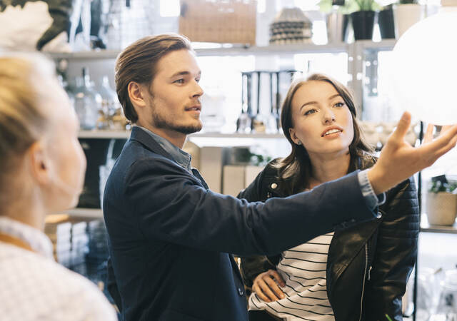 Customers shopping for lamps at a retail store.