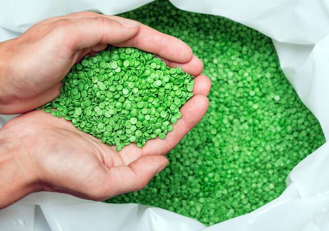 Hands holding biodegradable plastic pellets